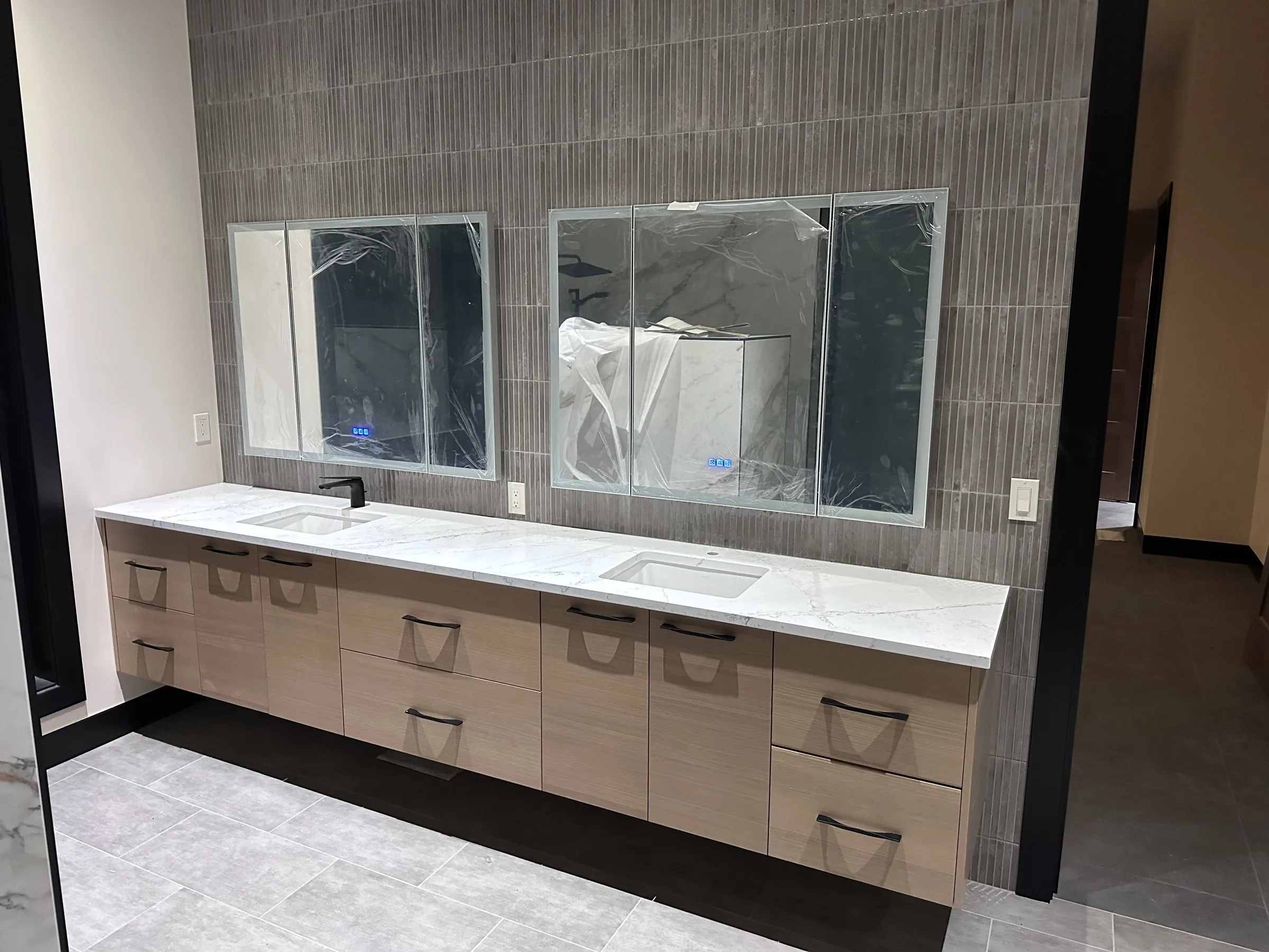 Large-format gray floor tile beneath a floating bathroom vanity