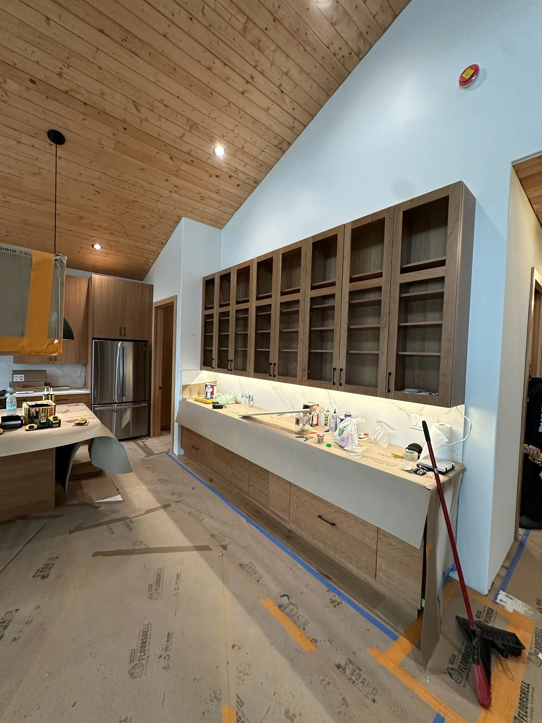 Wall of custom glass-front upper cabinets with open shelving