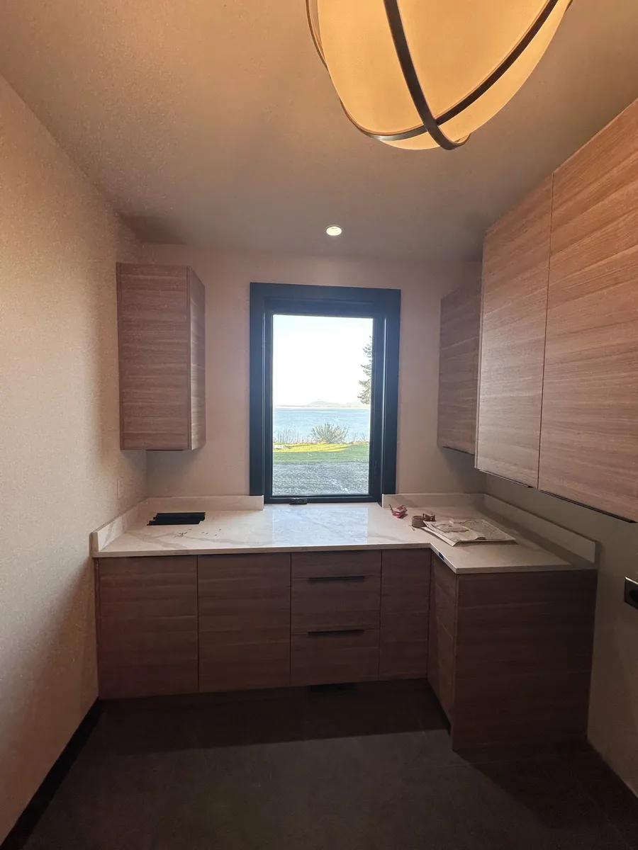 Laundry room with slab-door cabinets and a window looking out on the water