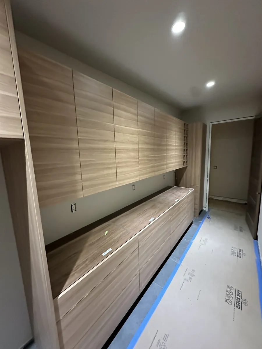 Wall of wood-grain built-in cabinets with wine cubbies